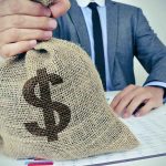 How China is FUNDING IRAN! Businessperson holding a burlap money bag on a desk