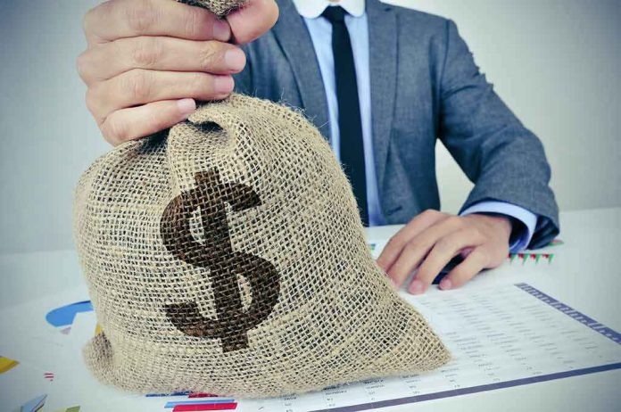 Businessperson holding a burlap money bag on a desk