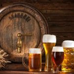 BELOVED BREWERY on the LINE — TRUTH FINALLY EXPOSED! assorted beer glasses in front of a wooden barrel