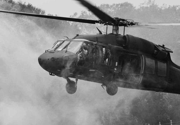 shutterstock_485723479 Military helicopter hovering with soldiers at open door
