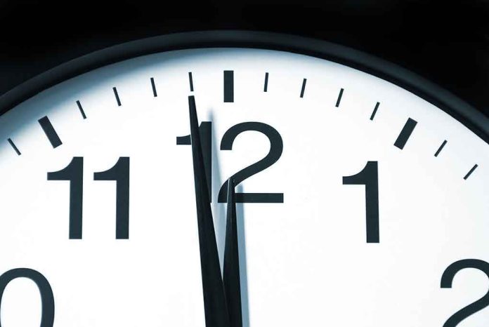 shutterstock_55812874 Close-up of a clock showing the time just before noon