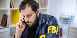TOTALLY UNEXPECTED — FBI PROTECTED ‘Person of High Interest’ — WHY?? Man in FBI jacket talking on a phone at a desk