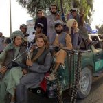 Taliban Ban EXPOSED — Boys Still HUNTED! Armed men sitting on a pickup truck.
