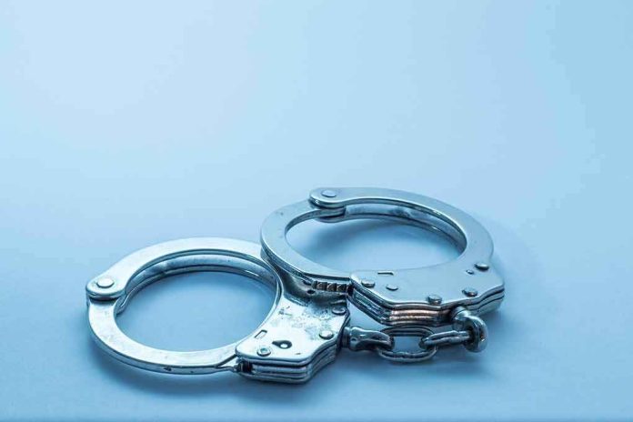 shutterstock_1098085049 Metal handcuffs on a light blue surface