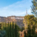 MAJOR Hollywood EXIT LOOMING Hollywood Sign on hillside framed by trees