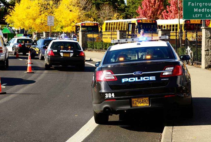 Police cars with lights on near school buses on a city street