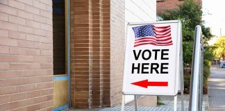 Sidewalk sign with American flag directing to a polling place