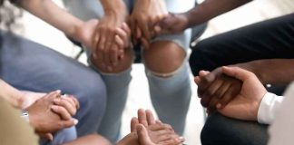 Group holding hands in a supportive circle