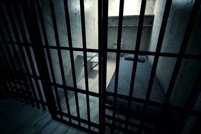 shutterstock_138714137 Interior view of a prison cell with a bed and metal bars