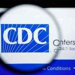 Magnifying glass over CDC logo on a computer screen