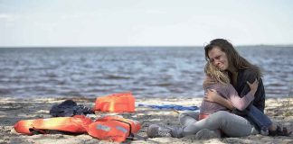 Beach Day Turns BATTLEFIELD — Kids Among Dead Mother hugging child on a beach near life jackets