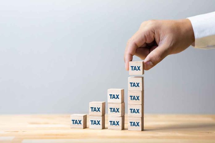 shutterstock_1724602342 Hand stacking wooden blocks labeled TAX into ascending columns