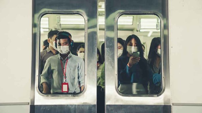 shutterstock_1851038077 Commuters wearing masks inside a crowded subway train
