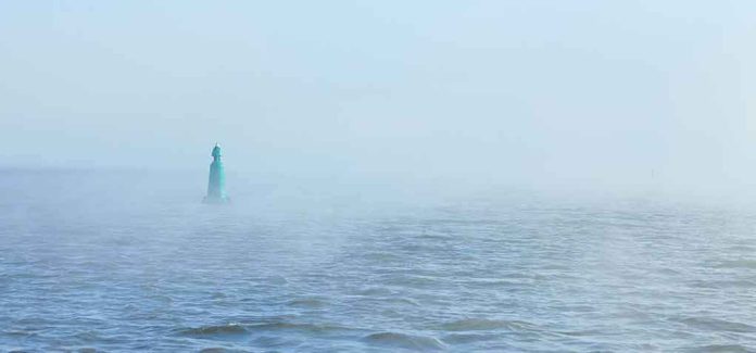 shutterstock_1870019050 Green buoy in foggy sea