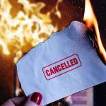 VISA Purge Looms — 200,000 On The Line Burning paper stamped cancelled held by hand