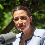 woman speaking at an outdoor microphone