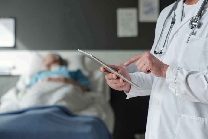 Doctor using tablet beside hospital patient