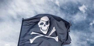 Pirate HUNT Ends In Blood A black pirate flag featuring a skull and crossbones waving against a cloudy sky