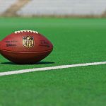 FBI Busts ‘49ers’ Love CON American football on a green field near a white line