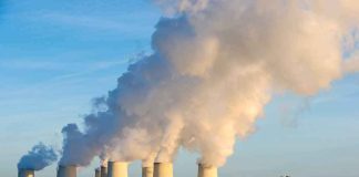 River VANISHES — Reactors Go Dark Cooling towers emitting steam at a power plant by a river