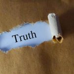 Torn brown paper revealing the word 'Truth' on white background