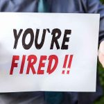 Judge FIRED After Calling TRUMP’S Policy Unethical person holding a sign that says you're fired