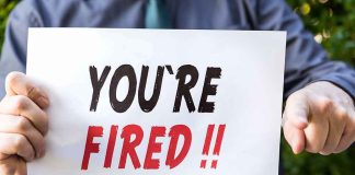 person holding a sign that says you're fired