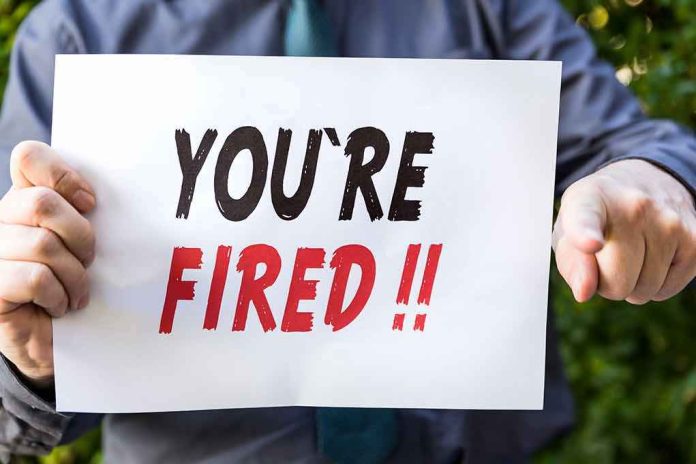 person holding a sign that says you're fired