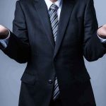 Businessperson in suit shrugging with open hands