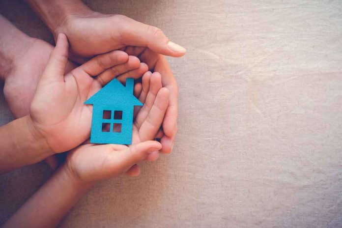 Hands holding a blue house cutout