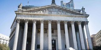 Reporters and photographers gathered outside a neoclassical courthouse