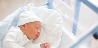 Newborn baby sleeping in hospital bassinet