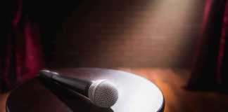 Daytime Star Bragged On Air — Then Someone Checked The RECORD Microphone on a round stool under stage spotlight