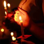 Everyone Saw How She Was Found — Which Was Exactly The POINT Hands holding lit candles in a dark setting