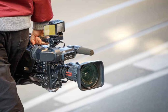 camera operator carrying a professional video camera