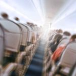 Locked Cockpit Door Couldn’t Stop This One — He Was Already INSIDE Airplane cabin aisle with blurred passengers and seats