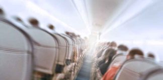 Locked Cockpit Door Couldn’t Stop This One — He Was Already INSIDE Airplane cabin aisle with blurred passengers and seats