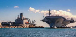 A Veteran Billed The Navy $9 Million — Wait Until You See For WHAT Aircraft carrier and support ships docked at a naval harbor