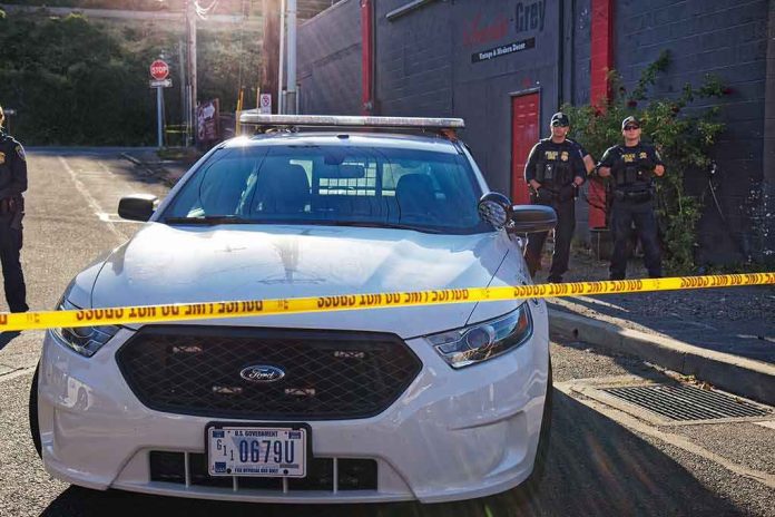 shutterstock_1143336623 Aaron Guiel near police car behind yellow caution tape