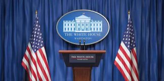 White House press podium with microphones and two American flags