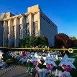 ARMED At Prayer — Then THIS Synagogue exterior with memorial flowers and star-shaped tributes on lawn