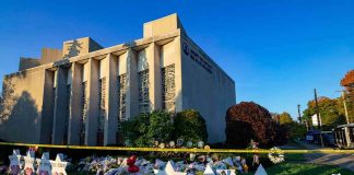 ARMED At Prayer — Then THIS Synagogue exterior with memorial flowers and star-shaped tributes on lawn