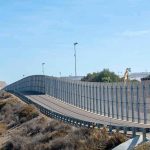Mile-Deep Reactor? Washington Says GO Tall metal border fence curving through arid landscape