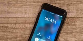 Thief Never Cracked A Password. So WHO Opened The Door? Smartphone showing an incoming scam call on a wooden surface