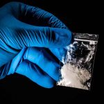 It’s Stronger Than FENTANYL — And The Test Strips Can’t See It Gloved hand holding a small plastic bag of white powder