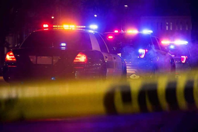 Police cars with flashing lights behind yellow caution tape at night