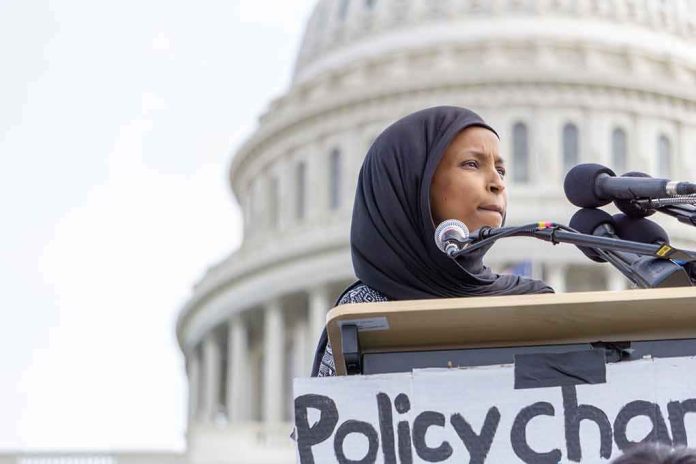 shutterstock_1355305115 Ilhan Omar speaking at a podium with microphones in front of the U.S. Capitol