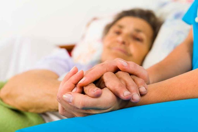 shutterstock_161459273 Caregiver holding hands with an elderly patient in bed