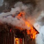 Wildfire Cash Diverted — LOOK Who Got Paid! Wooden house engulfed in flames and thick smoke
