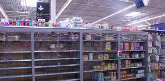 Partially empty store shelves with baby formula and supplies